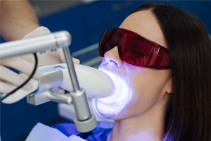 lady sitting up getting her teeth whitened